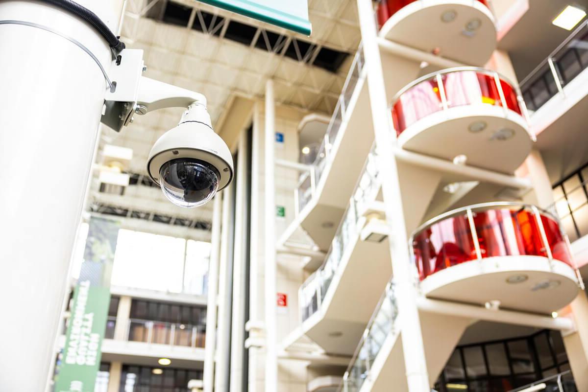 Looking up at a security CCTV camera on a column in a shopping centre